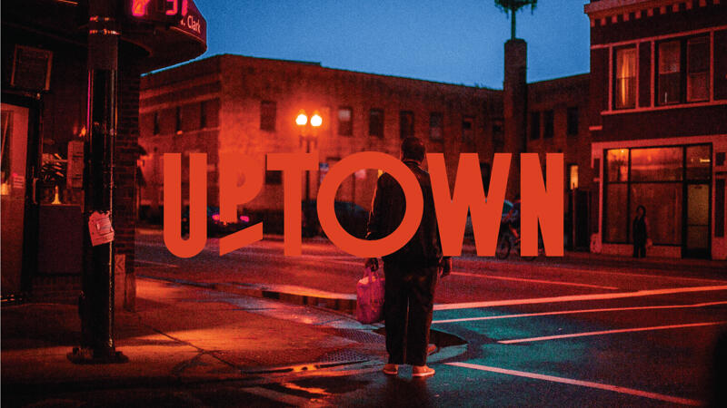 Uptown Logo overlaid on a dramatic evening neighborhood street scene